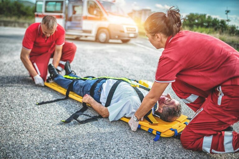 EMS assisting injured person from the scene of an accident.