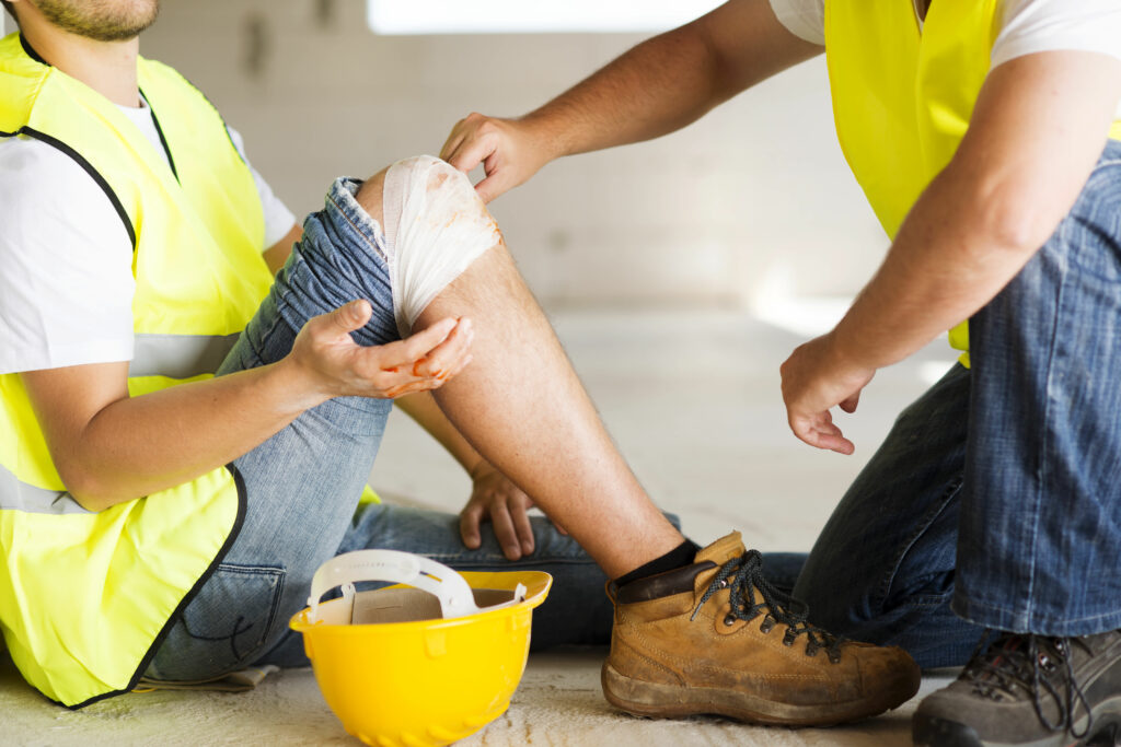 Injured construction worker receiving first aid at the scene.