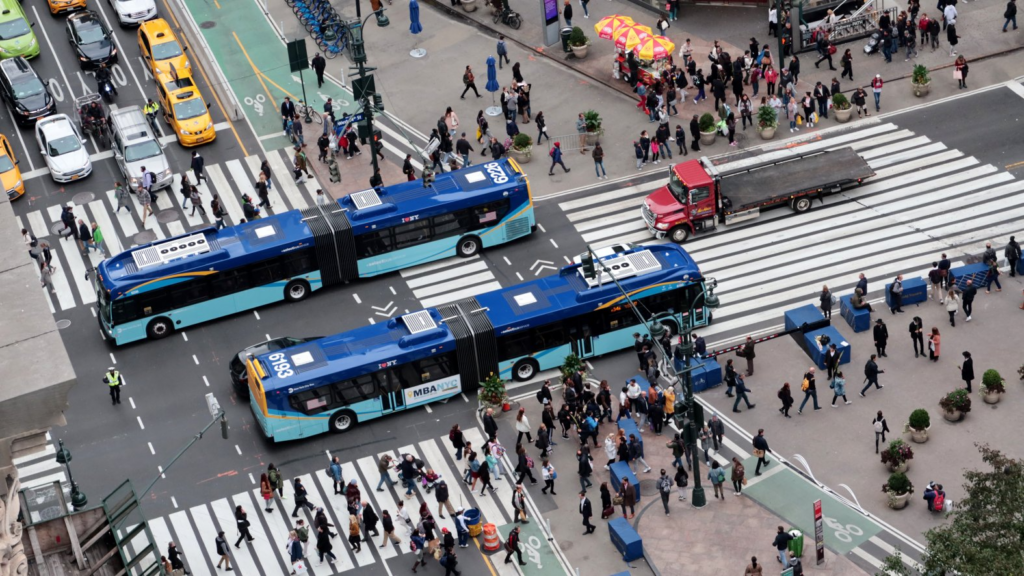 Buses traveling through crowded intersection.