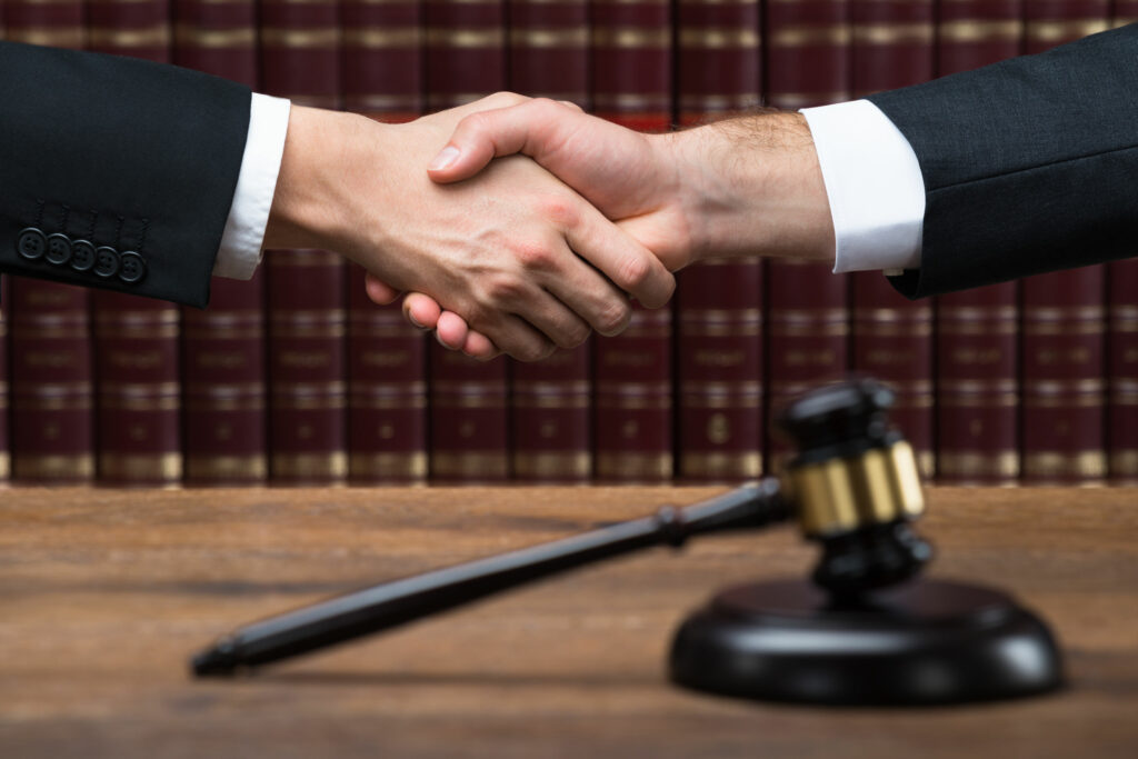 Lawyers Shaking Hands in courtroom after trial.