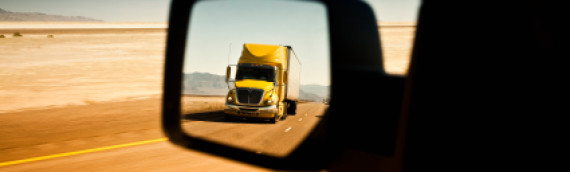 Large truck approaching a motor vehicle.