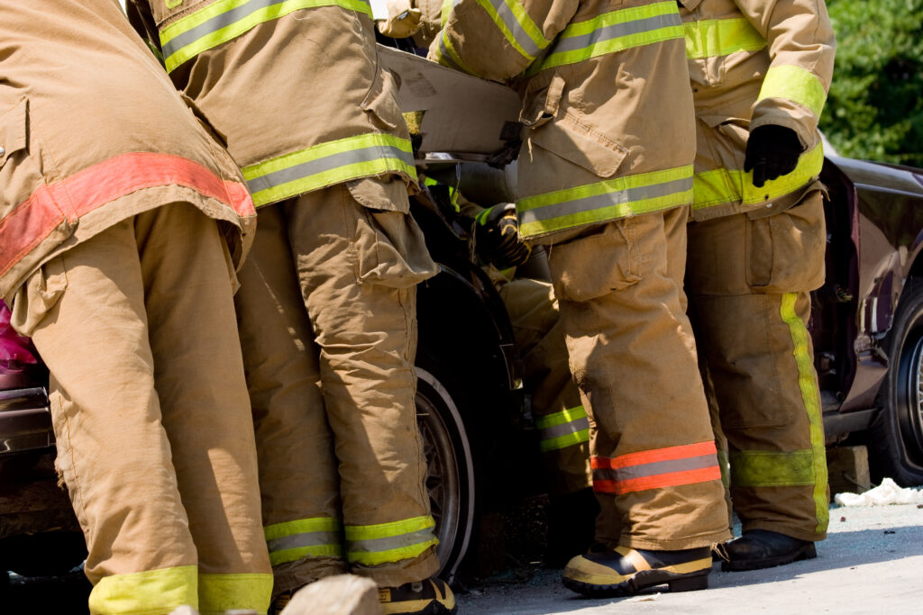 Firefighters work to extract a victim from his vehicle at the scene of an accident.